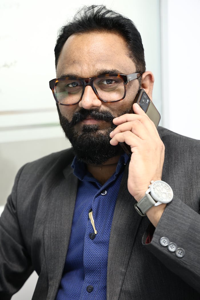 why-choose-us Businessman in gray suit and eyeglasses talking on phone.