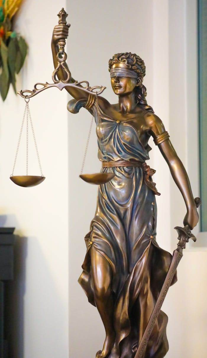 Bronze Lady Justice statue with scales and sword, symbolizing law and fairness, displayed indoors in İstanbul.