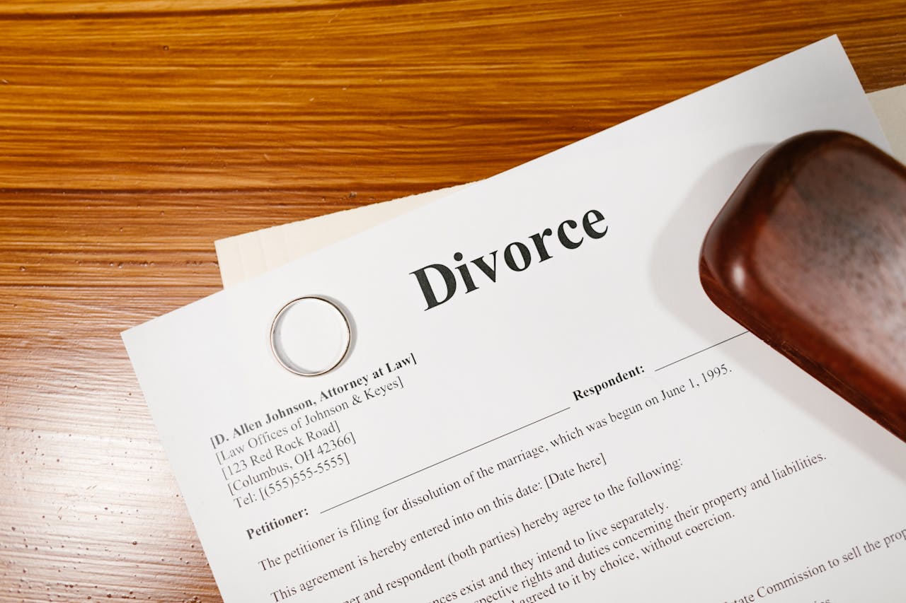 services-01 Close-up of a divorce document and wedding ring on a lawyer's desk.